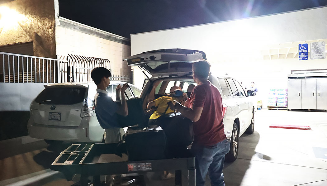 Tzu Shao and volunteers loading distribution items in a car