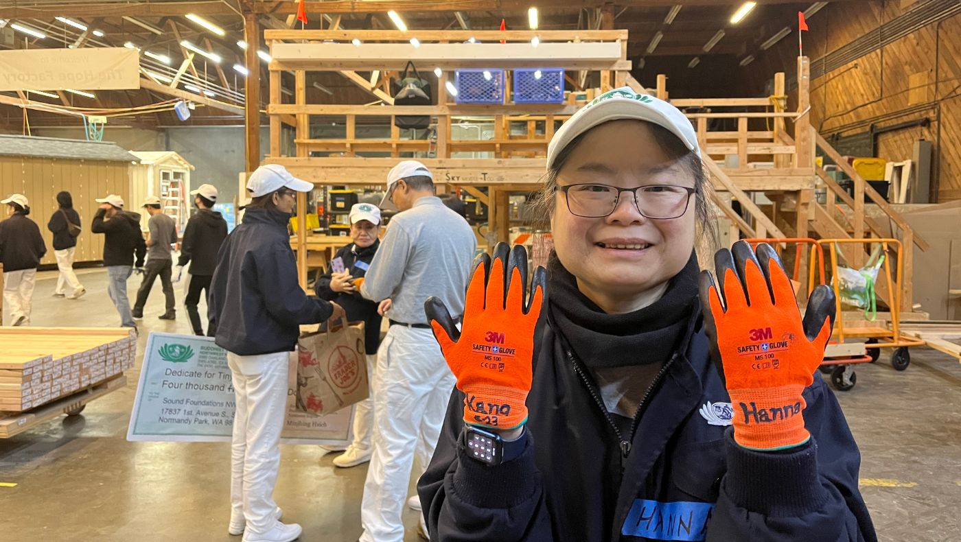 Volunteers who participate in tiny home construction several times receive custom gloves, much to their delight. Photo/Xinqian Zheng