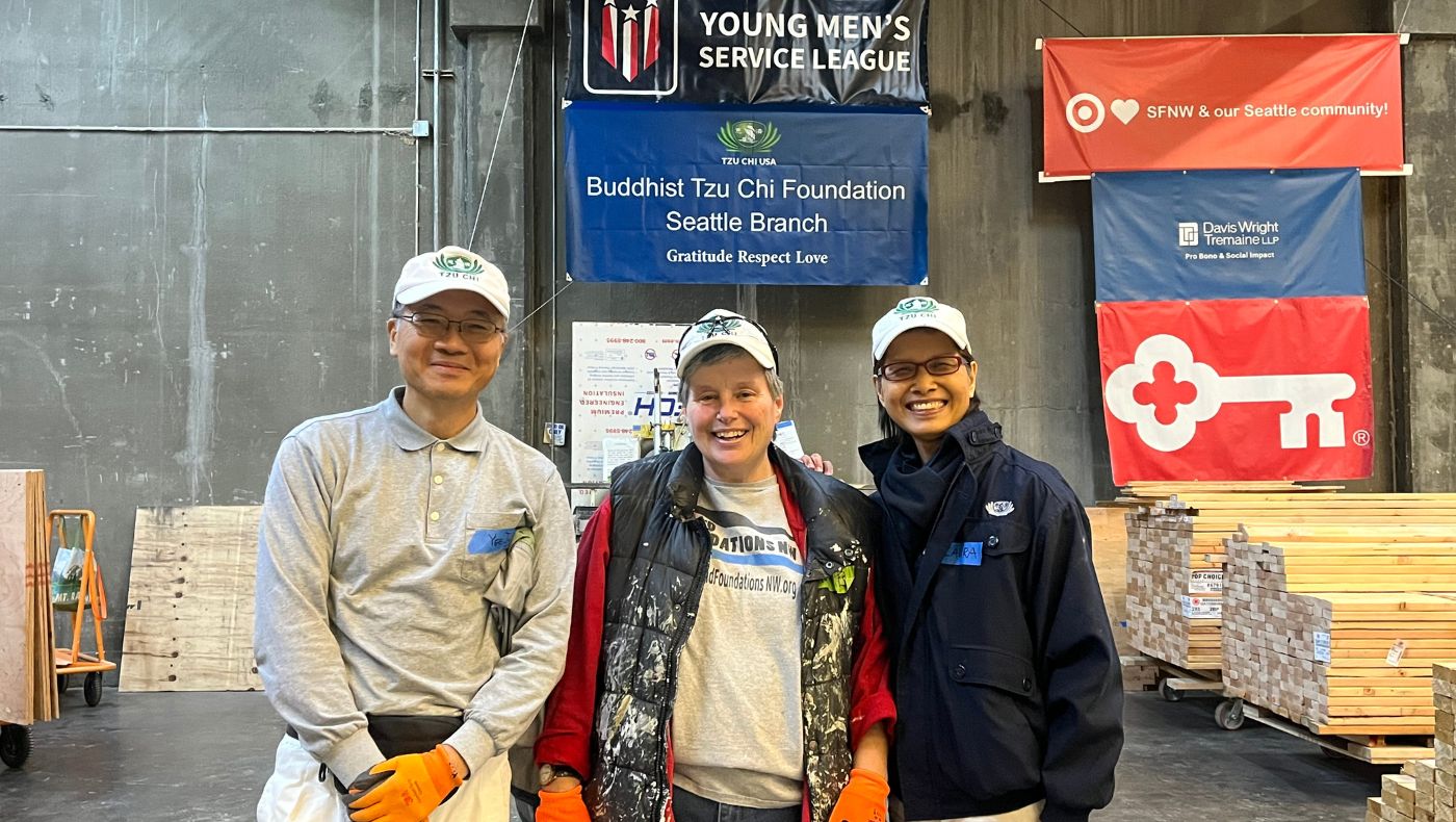 Yee Zu Wu (left) and Laura Chen (right) from Tzu Chi USA's Seattle Branch take a photo in the Hope Factory with Barb Oliver (middle), Director of Operations for Sound Foundations NW, to capture the joyful day that Tzu Chi donated a fourth tiny home. Photo/Xinqian Zheng