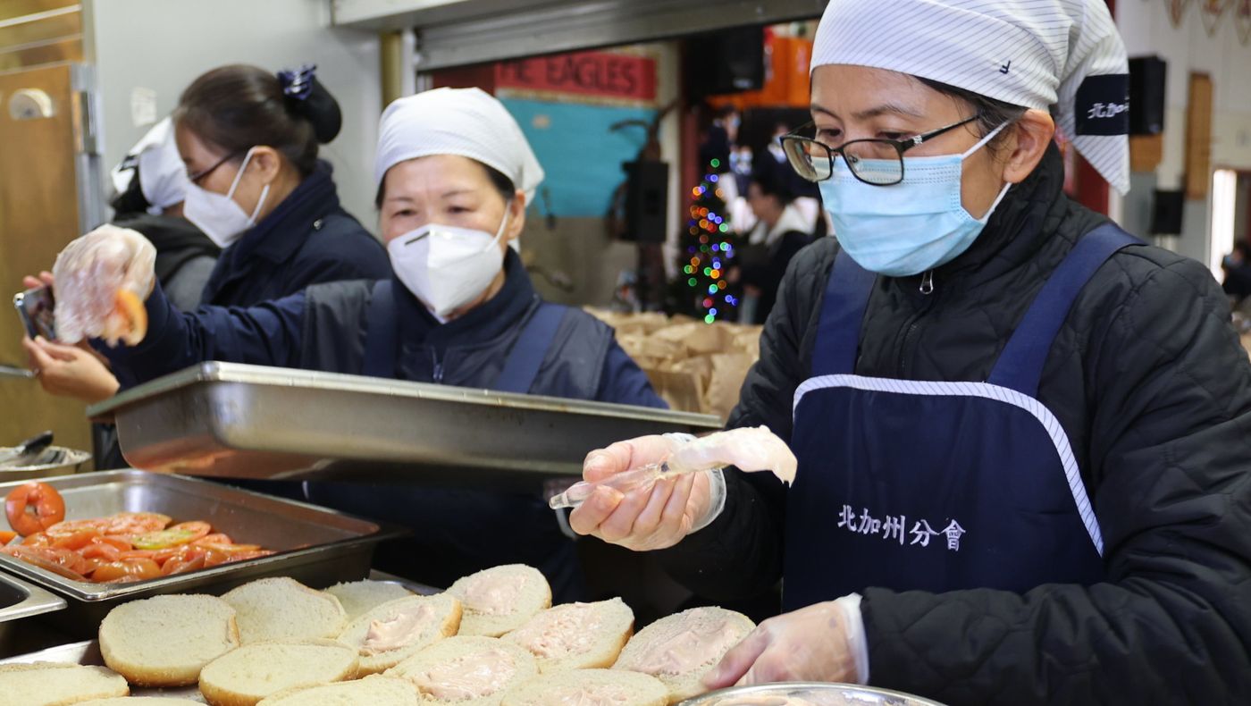 Volunteers Xue'e Wang (middle) and Suzhen Ma (right) busy in the kitchen. Photo/Kitty Lu
