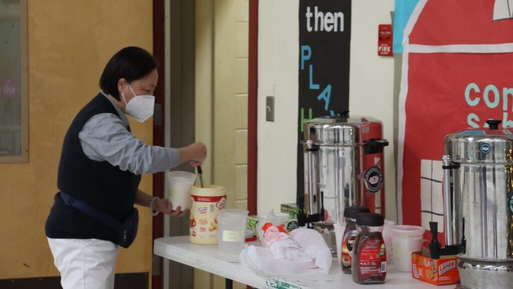 Volunteer Yinghua Liu and others offer hot drinks to warm up the participants. Photo/Kitty Lu