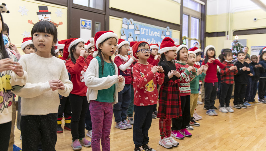 Children wearing Santa hats dancing