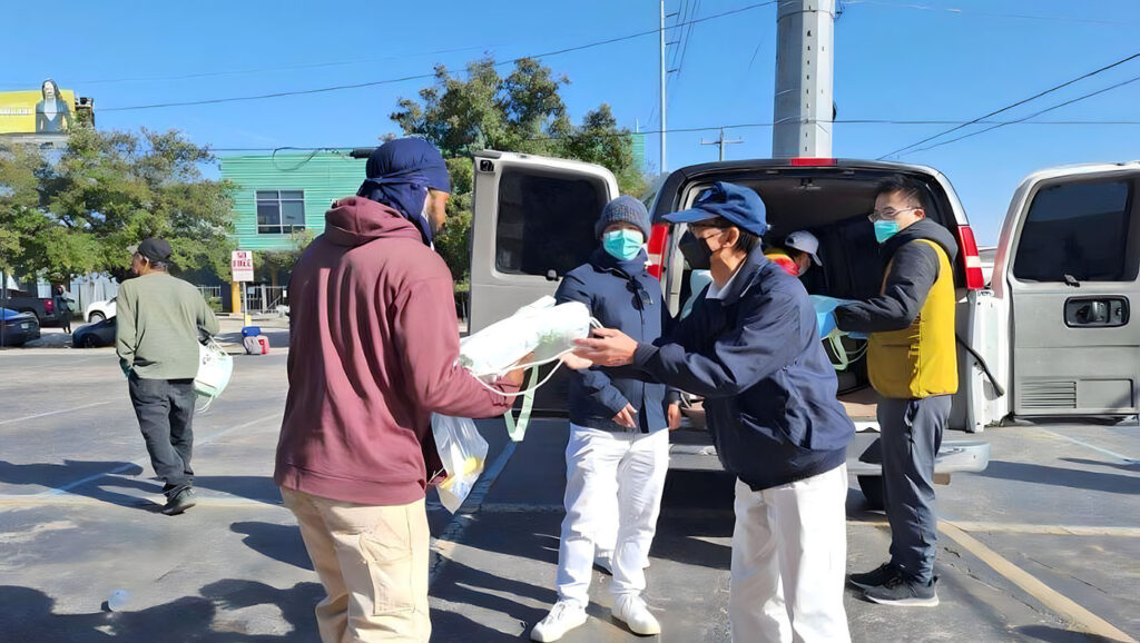 After opening their big cars, Tzu Chi volunteers began to distribute cold winter supplies to street residents.