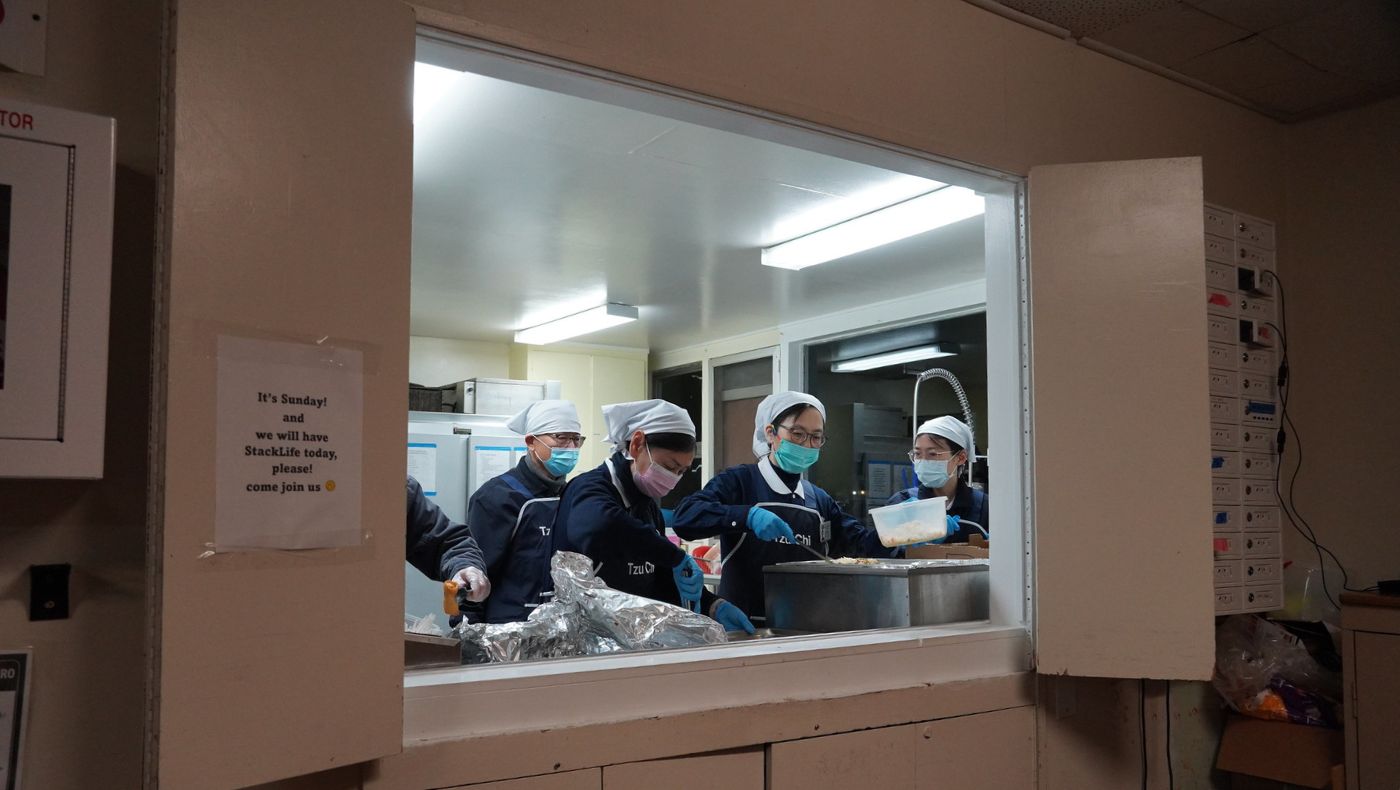 Volunteers who are responsible for distributing dinners work in the small kitchen of the church shelter.