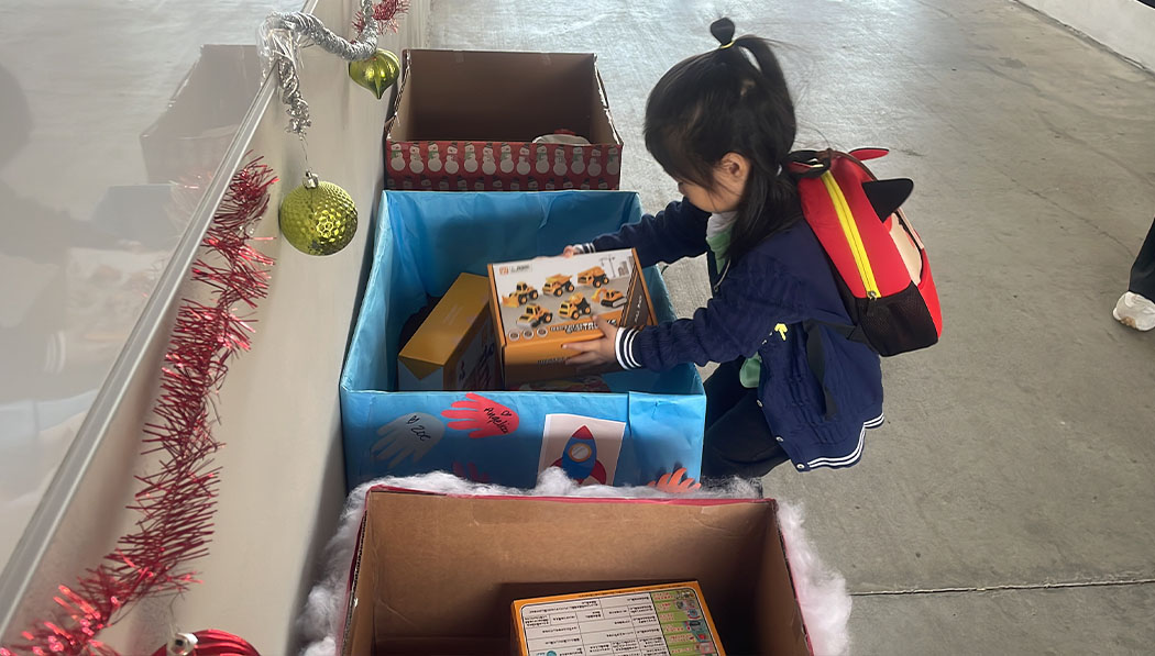 Children put their carefully selected toys into the toy drive box