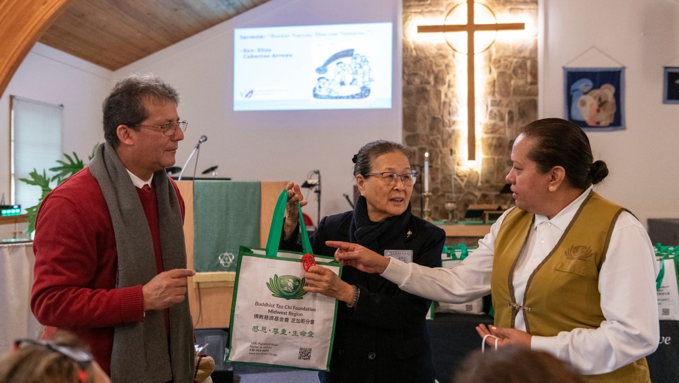 Tzu Chi volunteer Yamei took the stage to introduce the winter supplies distributed to the church members.