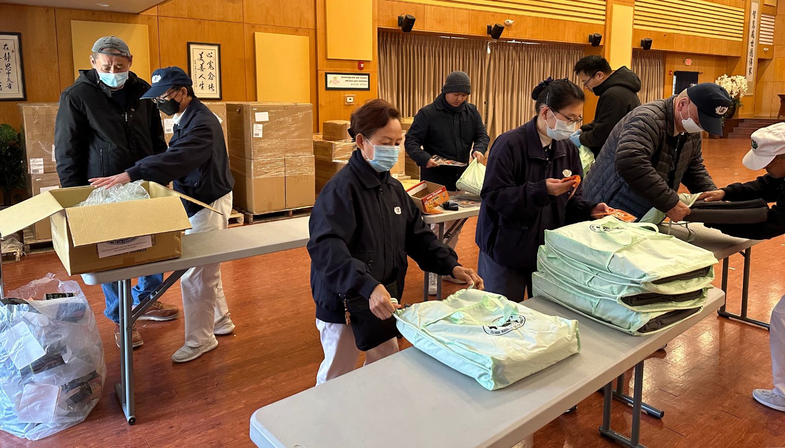 Tzu Chi volunteers pack and distribute blankets, socks and heating packs at the club.