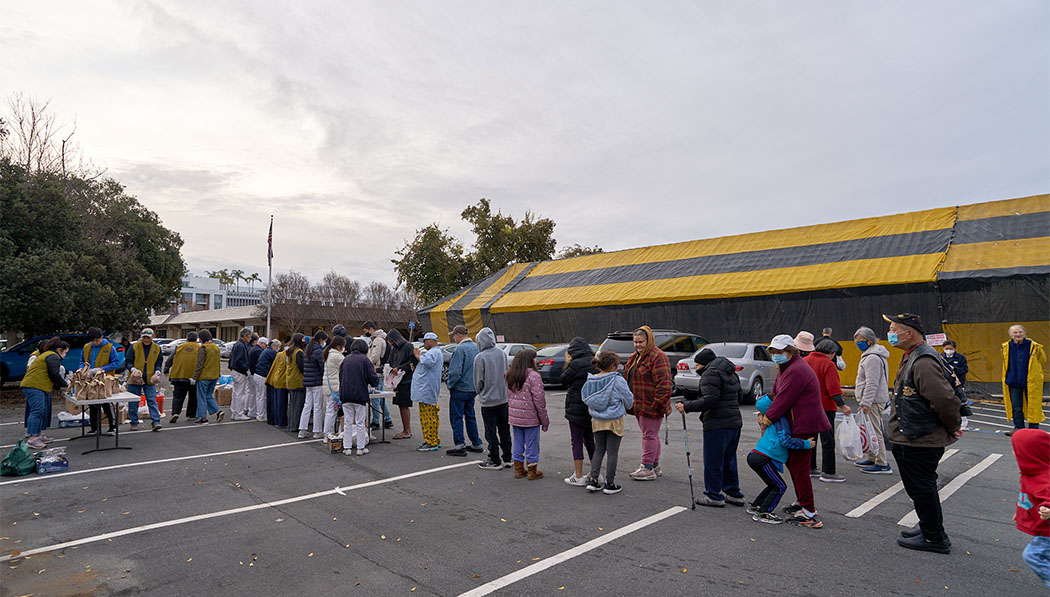 unhoused neighbors and people in need line up to receive breakfast