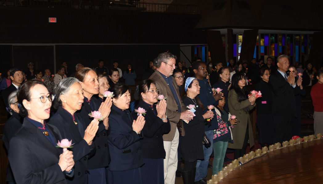 Tzu Chi volunteers and visitors praying together