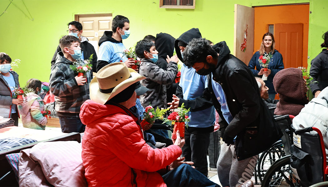 students offering flowers to the seniors in the nursing home