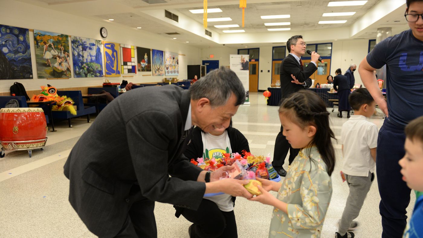 The little girl wore traditional Chinese festival clothes to receive the lucky bag.