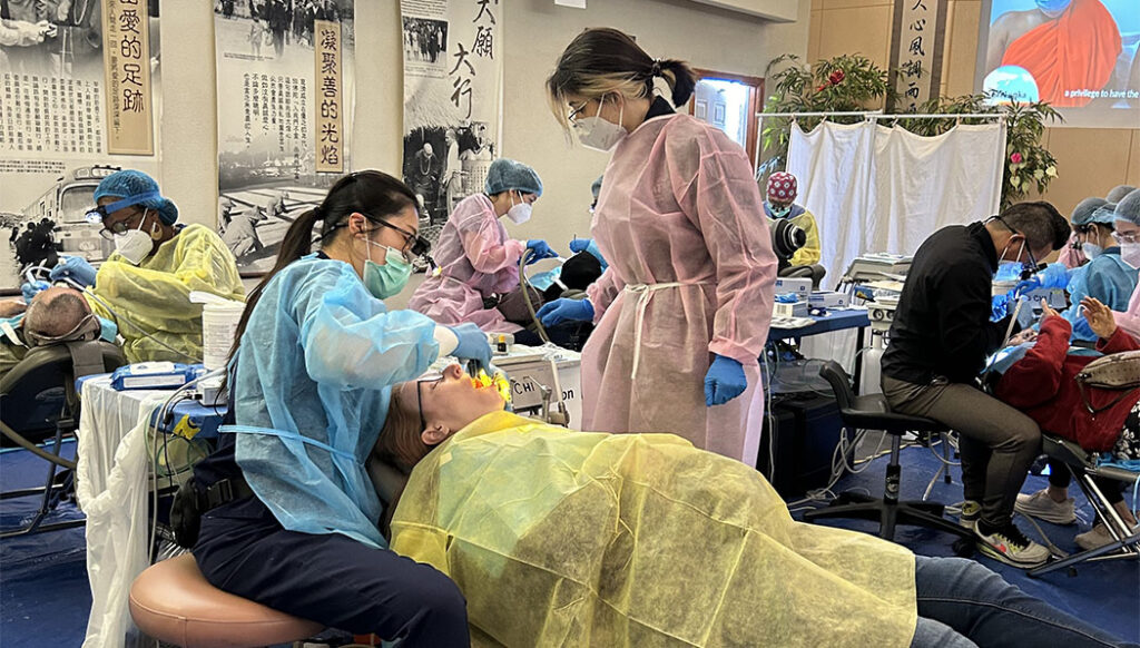 Dentistas prestan servicios médicos a los pacientes, mientras los auxiliares ayudan desde el lateral. Foto/Oficina Nacional de Tzu Chi