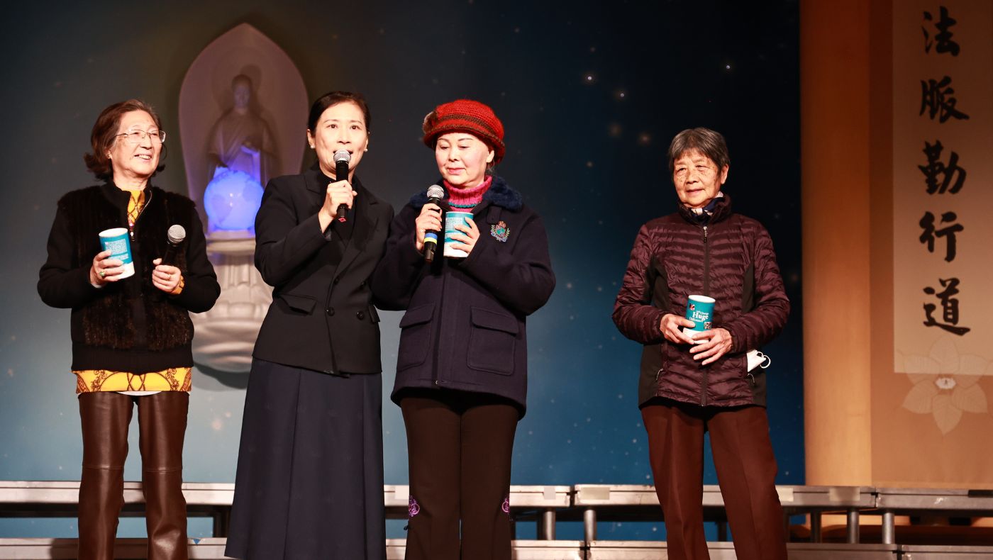 Elder Wang Ying (second from right), accompanied by Tzu Chi volunteer Zhang Cishi, took the stage to share his feelings.