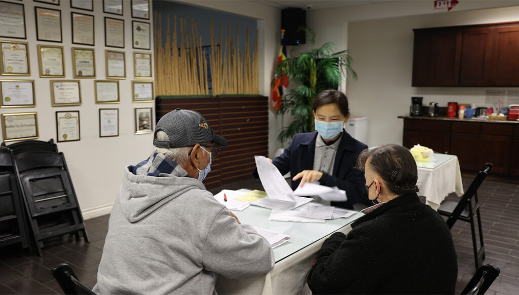 Tzu Chi volunteer Cindy Wei helps Monde Garcia and his wife file their taxes