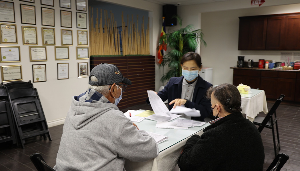 Tzu Chi volunteer Cindy Wei helps Raymond Garcia and his wife file their taxes