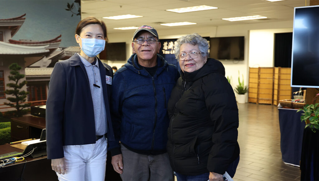 Tzu Chi volunteer Wei Xindi takes a photo with Irma Banuelos (right) and her husband who filed taxes