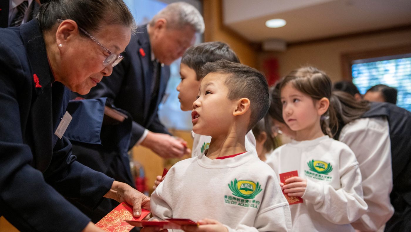 Cai Yamei and Xie Chongfu distributed blessing and wisdom red envelopes to the children.
