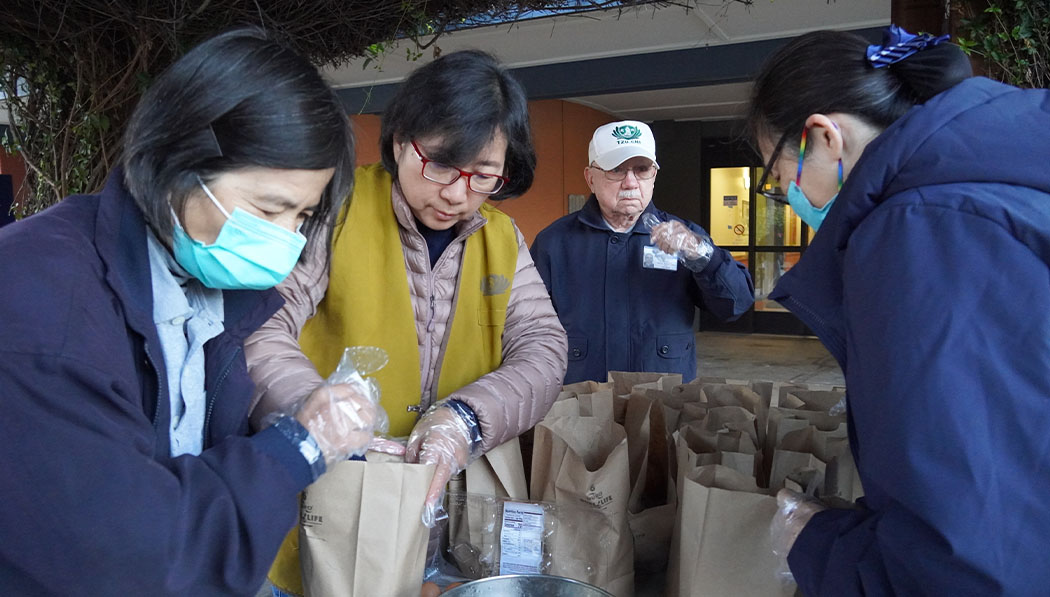Voluntarios de Tzu Chi se preparan con anticipación, empacando desayunos en bolsas de papel. Foto/Renee Liu