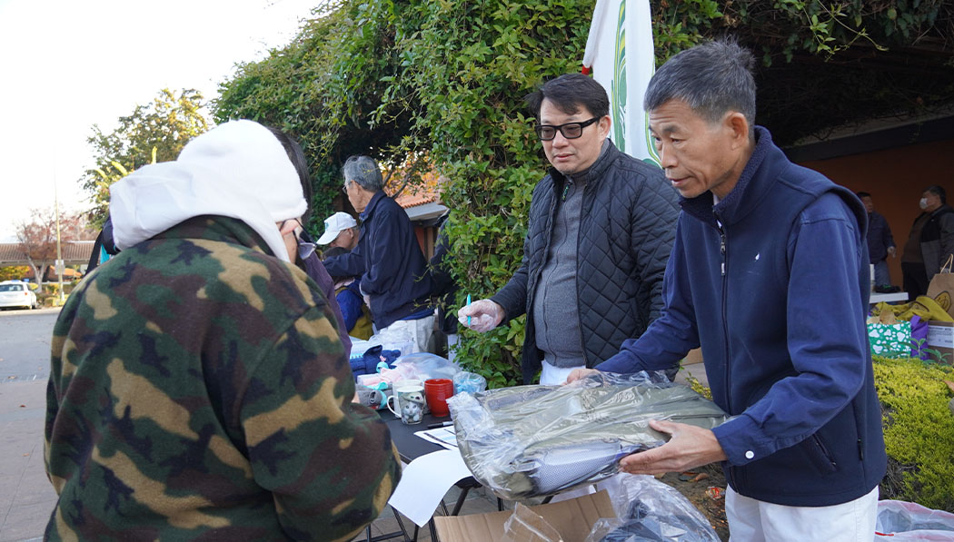 El voluntario Jason Lin distribuye mochilas nuevas a amigos de la calle necesitados. Foto/Renee Liu