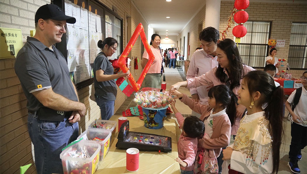 Parents and children shopping in the school campus's New Year Fair
