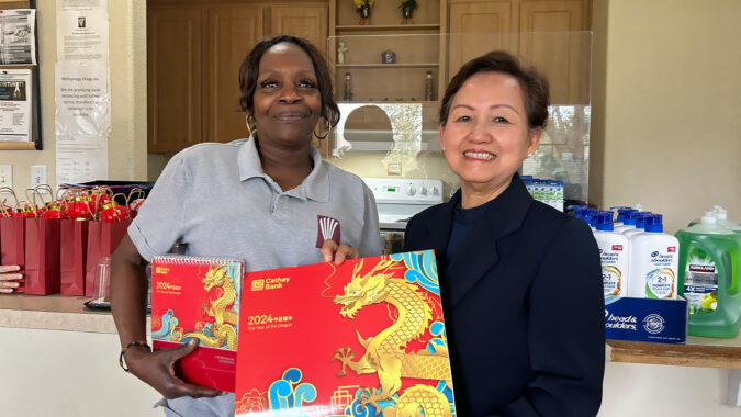Tzu Chi USA Southern Region representative offering Year of Dragon calendar to Wellsprings Village staff