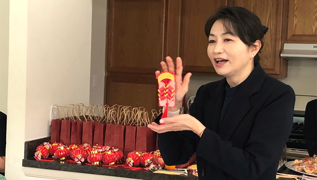 Volunteer Lin Huayin shares festive firecracker decorations made by students with everyone