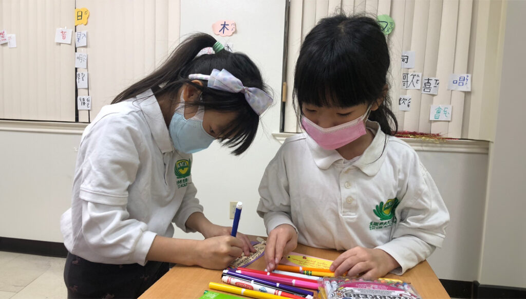 Estudiantes hacen decoraciones festivas de petardos y marcadores de aforismos de Jing-Si para compartir alegría con las damas del refugio para mujeres. Foto/Wendy Tsai