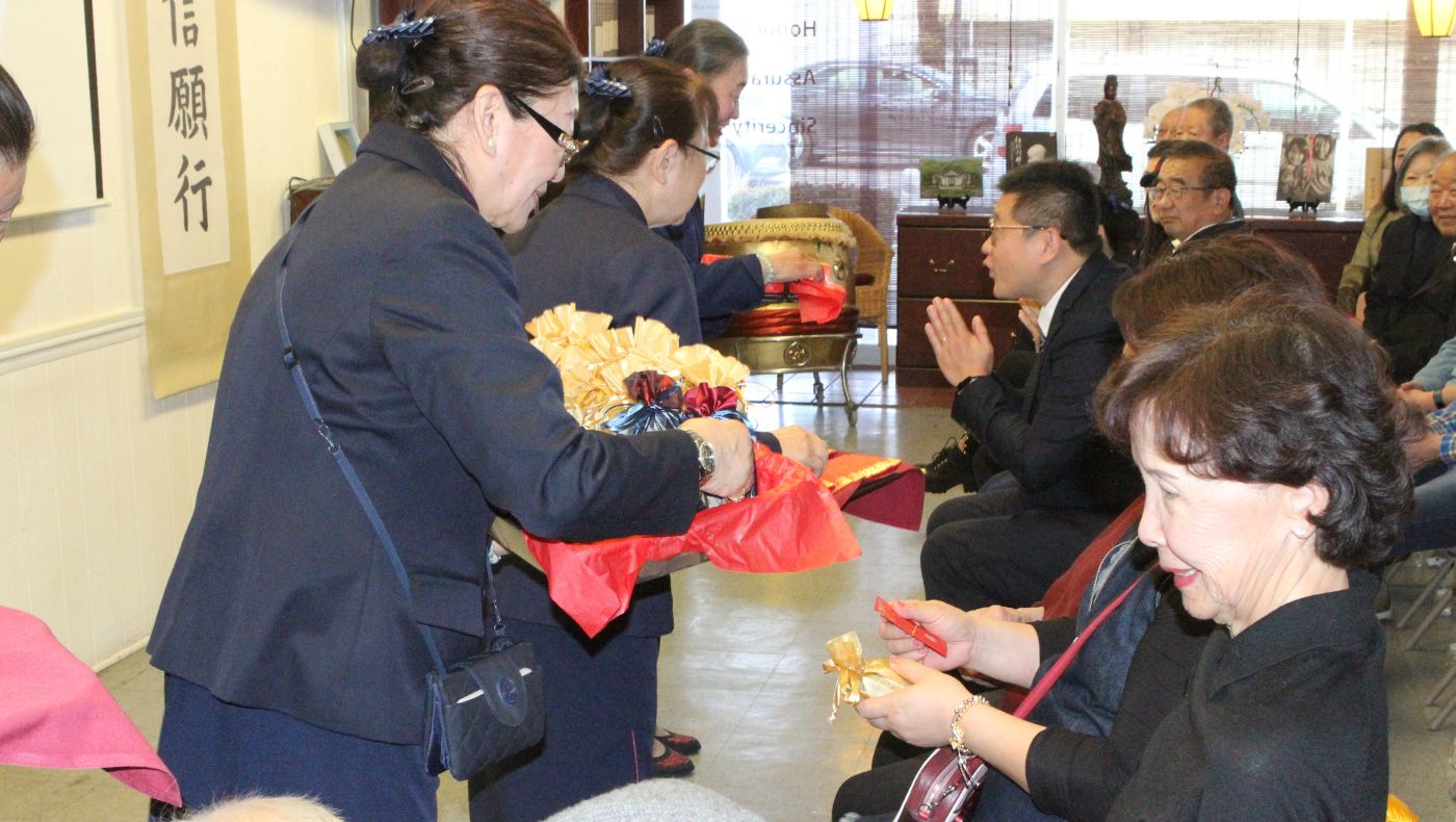 Tzu Chi volunteers presented Master Cheng Yen blessing and wisdom red envelopes and bonding gifts to the congregation.