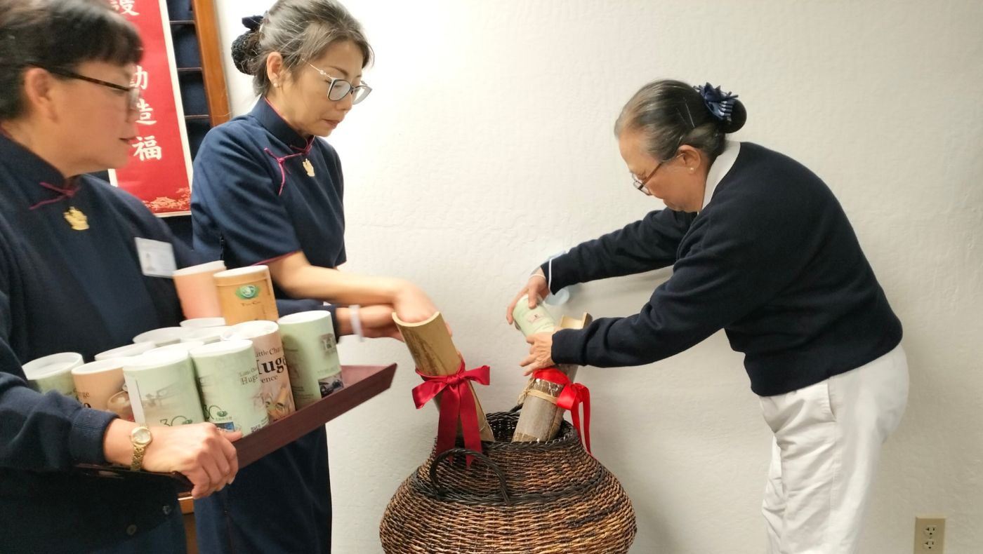 Volunteers held heavy bamboo tubes and poured the donations they had accumulated for a year into the merit box.