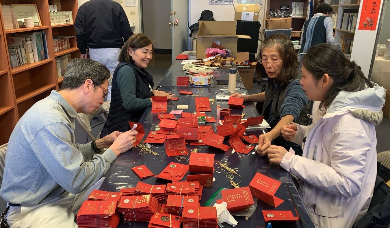 Volunteers worked together to make blessing and wisdom red envelopes for the blessing event.