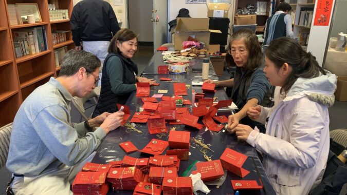 Volunteers worked together to make blessing and wisdom red envelopes for the blessing event.