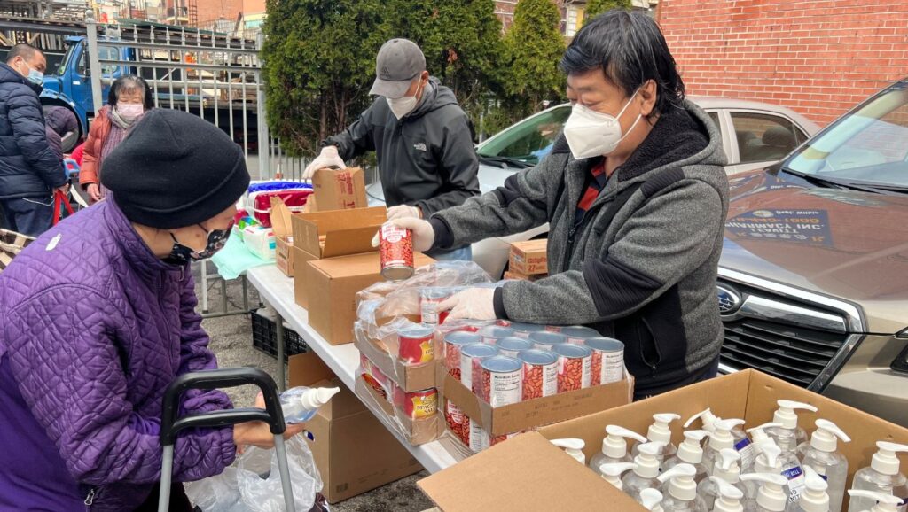 Mr. Wu and Tzu Chi volunteers sort out the goods for food distribution.