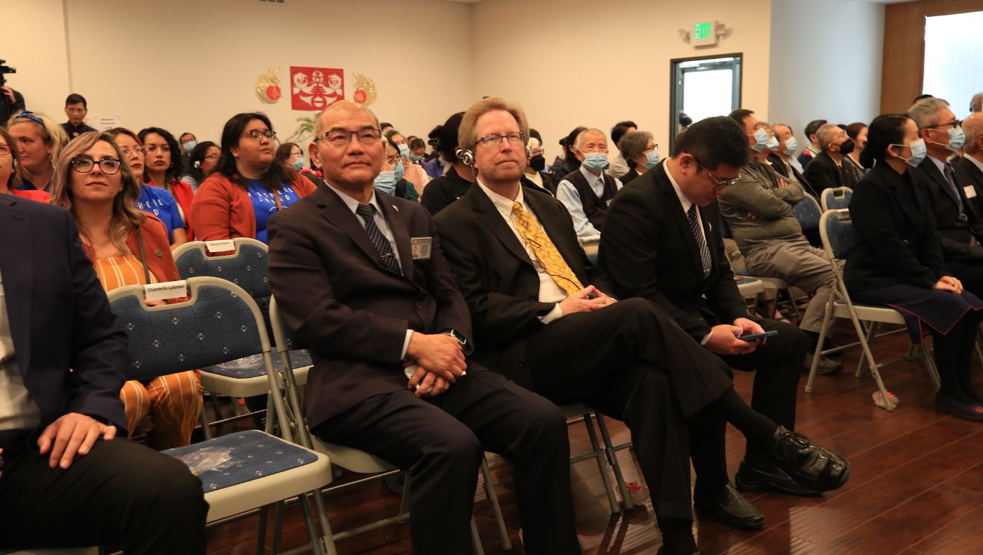 Mark Lowry (center, front row), director of the Orange County Food Bank, wears an instant translation headset and listens to Tzu Chi people sharing their footprints of love.