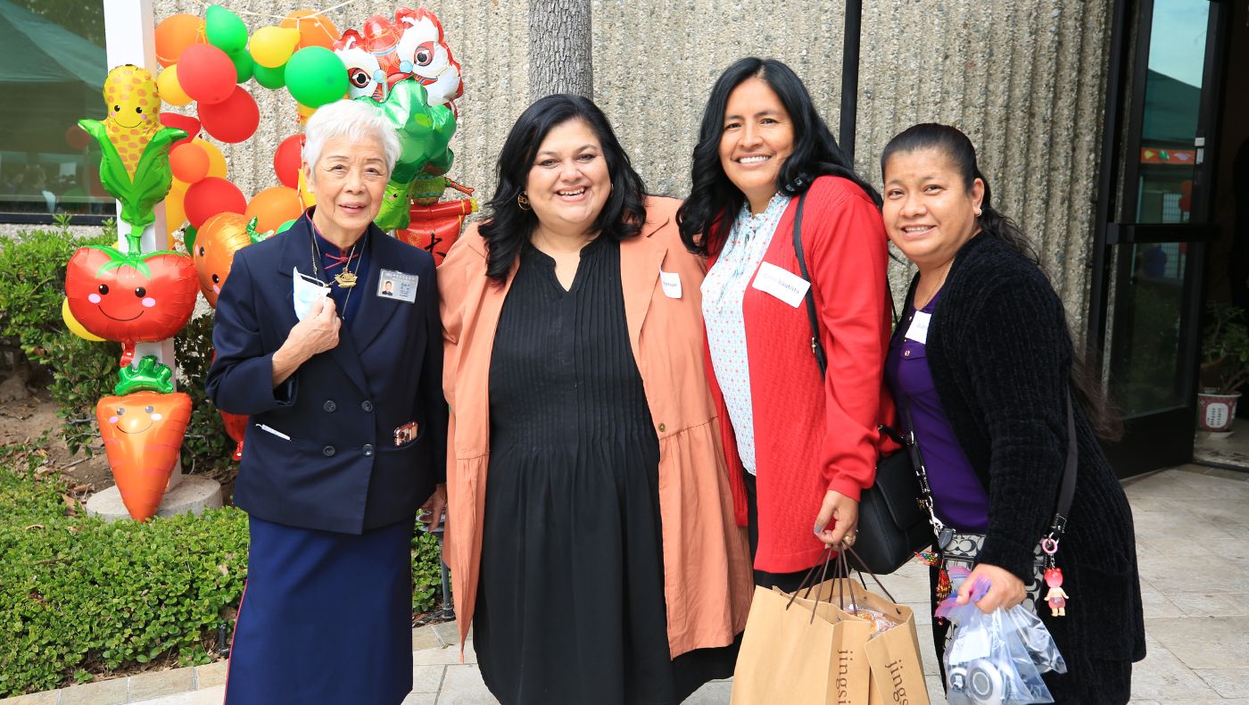Orange County volunteer Jian Ciheng (left) takes a group photo with Santa Ana City School District Family and Community Coordination Director Lisa Solomon (second from left) and Madison Elementary School parent Cecilia Bautista (third from left).