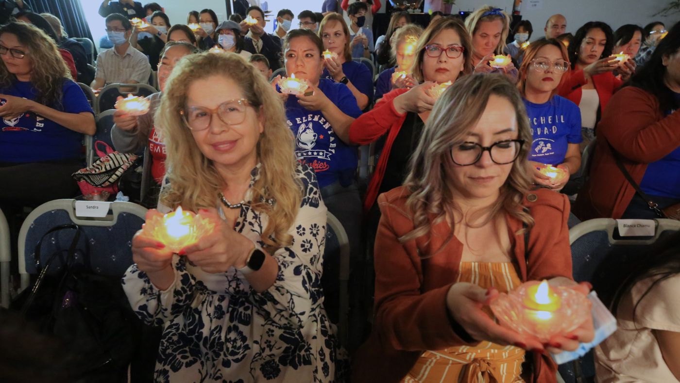 Davis Elementary School staff member Martha Patalup (left) lights candles and prays with everyone.