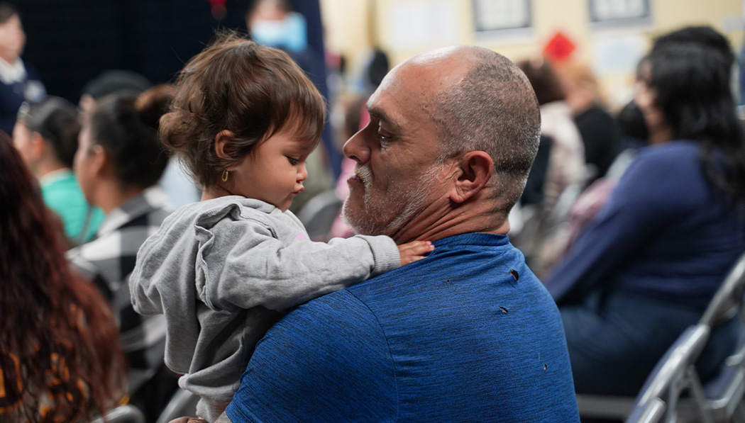 A man in blue shirt holding a little girl