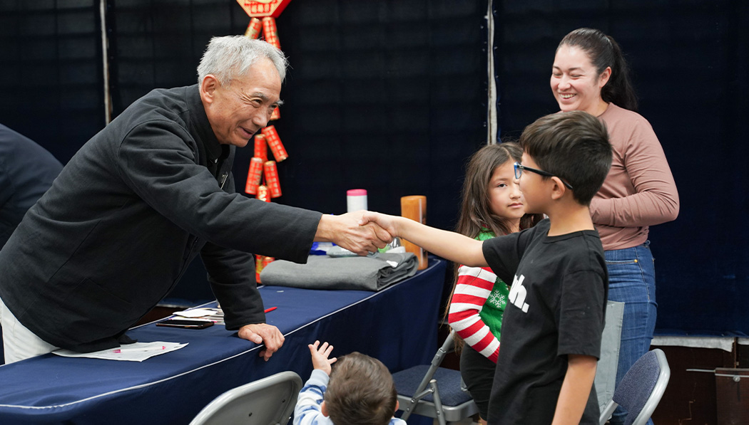 Tzu Chi volunteer and a kid having a hand shake