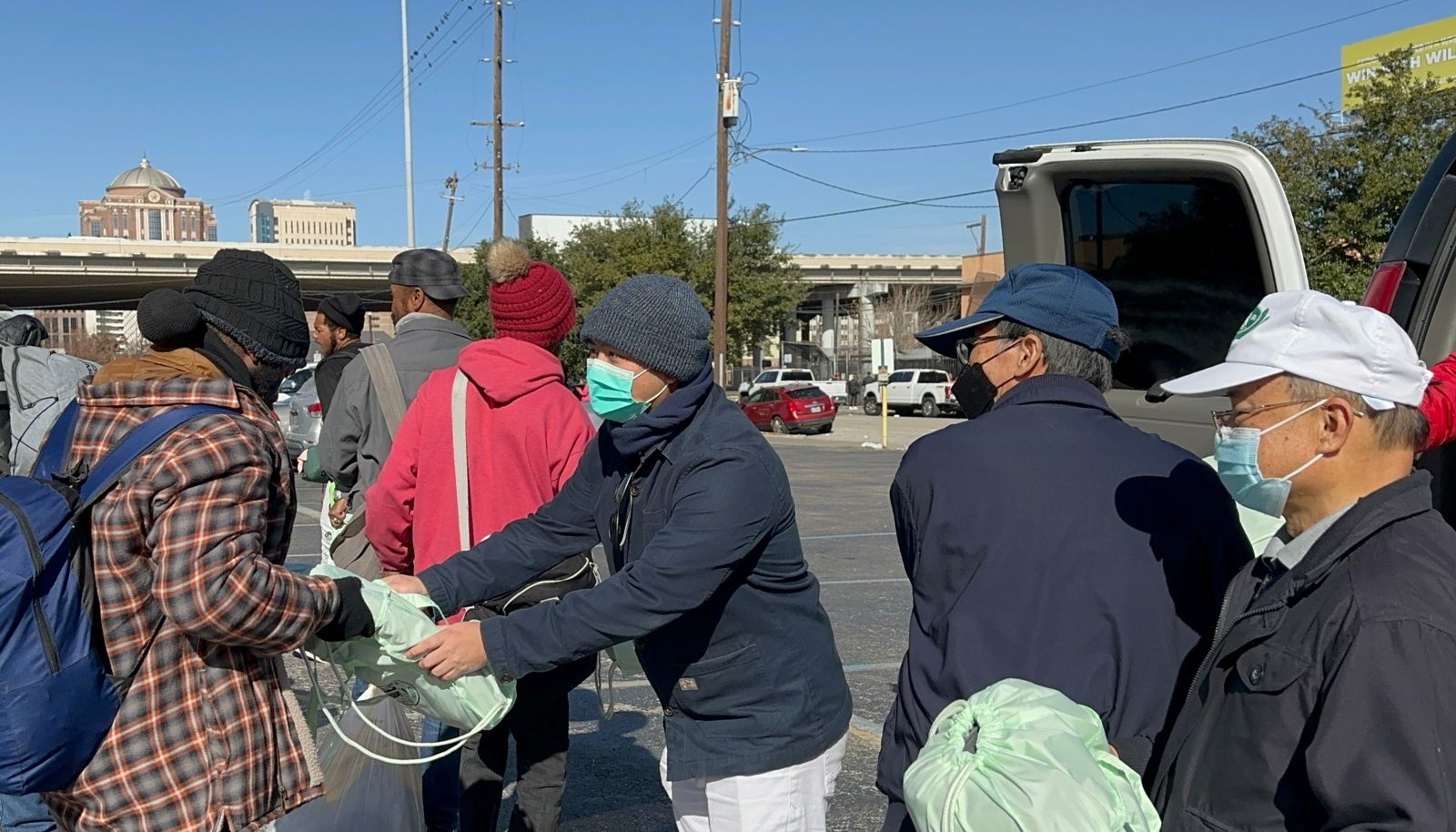 Voluntarios entregan respetuosamente mantas ecológicas y otros artículos para el frío. Foto/Eunice Pai