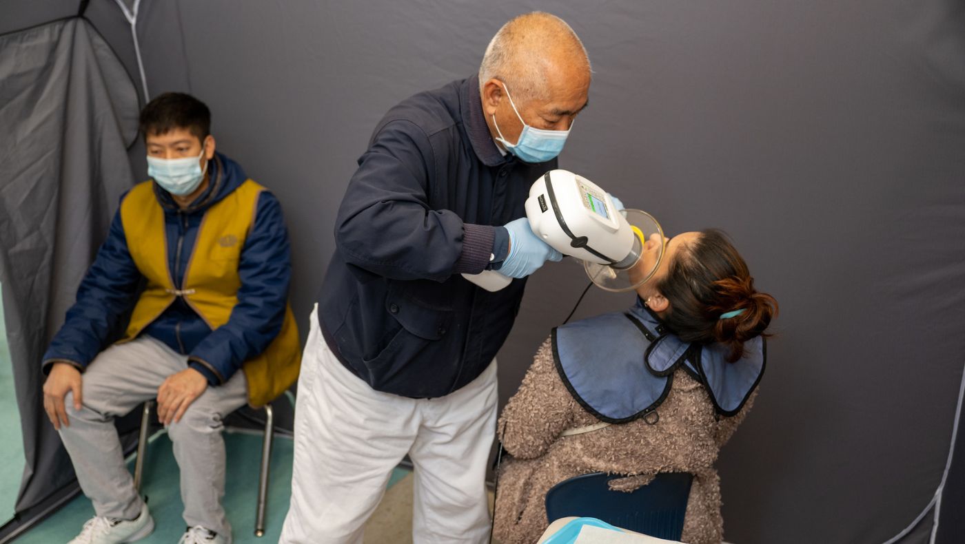Medical volunteers conduct X-ray examinations before people have their teeth extracted.