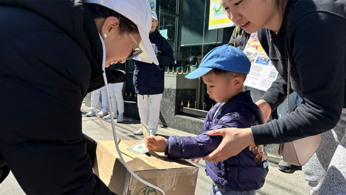 On the streets of Flushing, New York, a young boy donates money to earthquake victims.