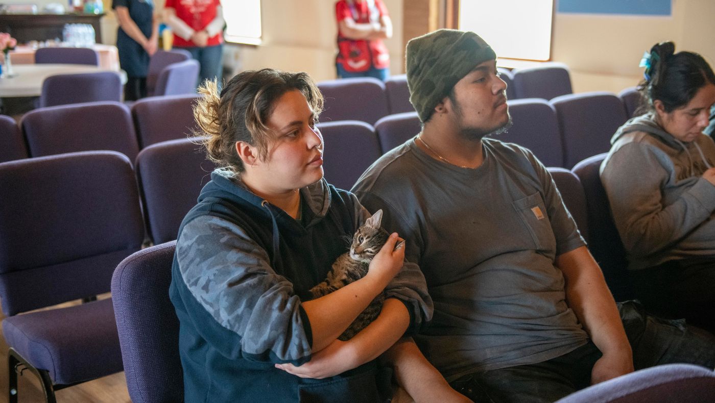 Alexia (far left) holds her beloved cat in a temporary shelter.