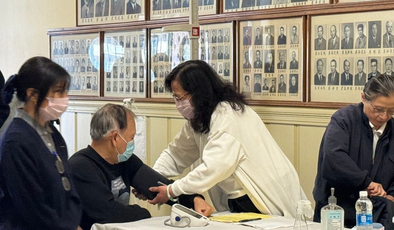 A free clinic doctor is taking a patient's blood pressure.