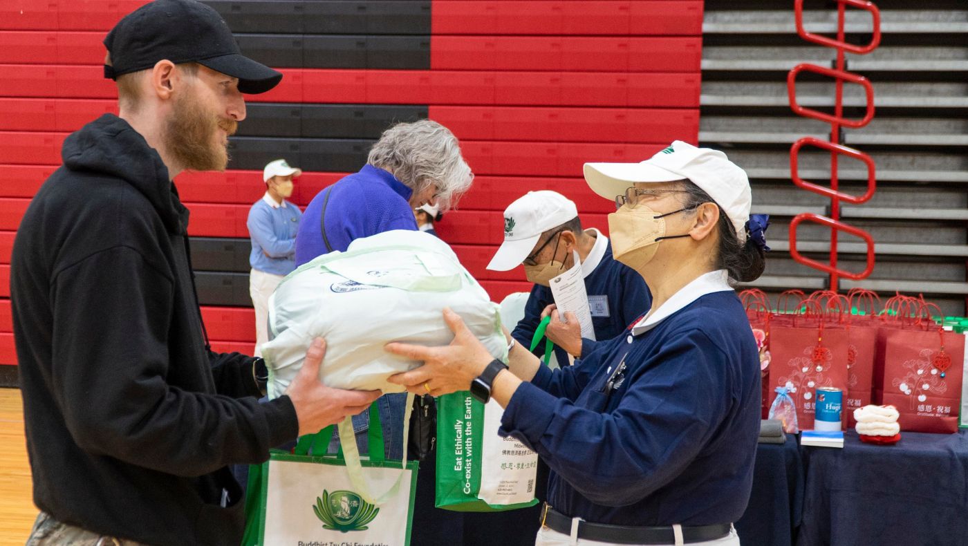 Tzu Chi volunteers distribute supplies to victims.
