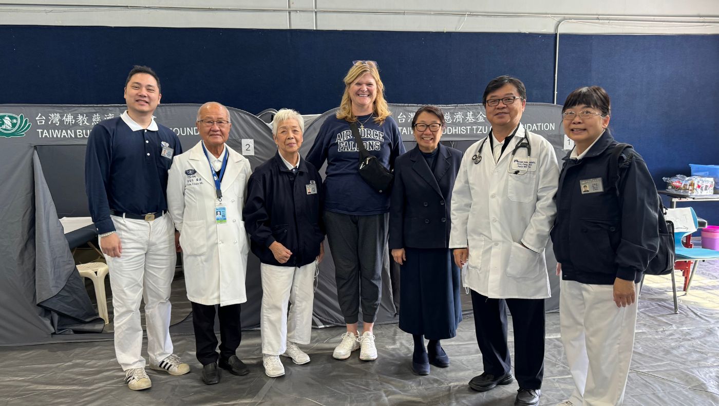 Hero Elementary School Principal Rebecca Clensilde (middle) takes a group photo with Tzu Chi USA CEO Tsang Cihui and members of the free clinic team.