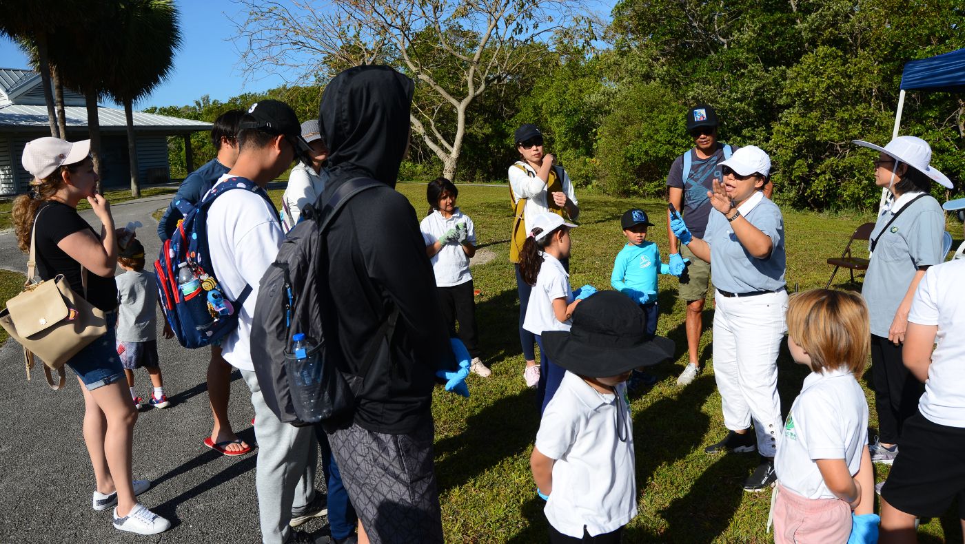 Tzu Chi volunteers distributed tools and garbage bags for beach cleanup activities to teachers, students, and parents in the school in front of the gathering pavilion.