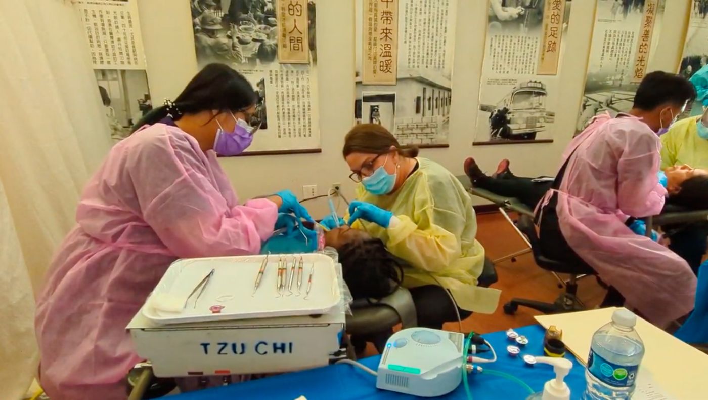 The doctor is cleaning the patient's teeth.