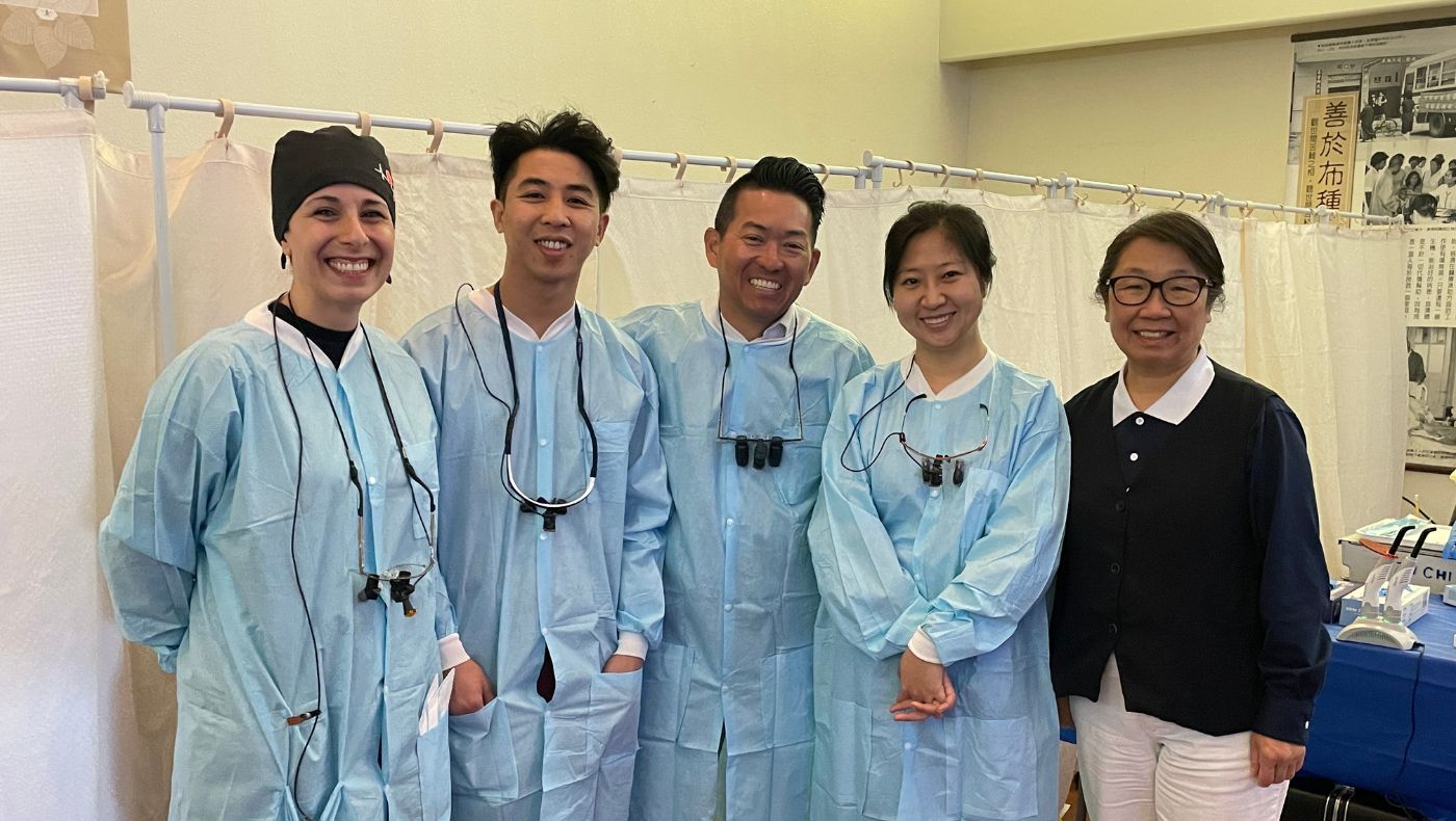 Dentists participating in the free clinic took a group photo with Tzu Chi USA CEO Tseng Cihui (first from right).