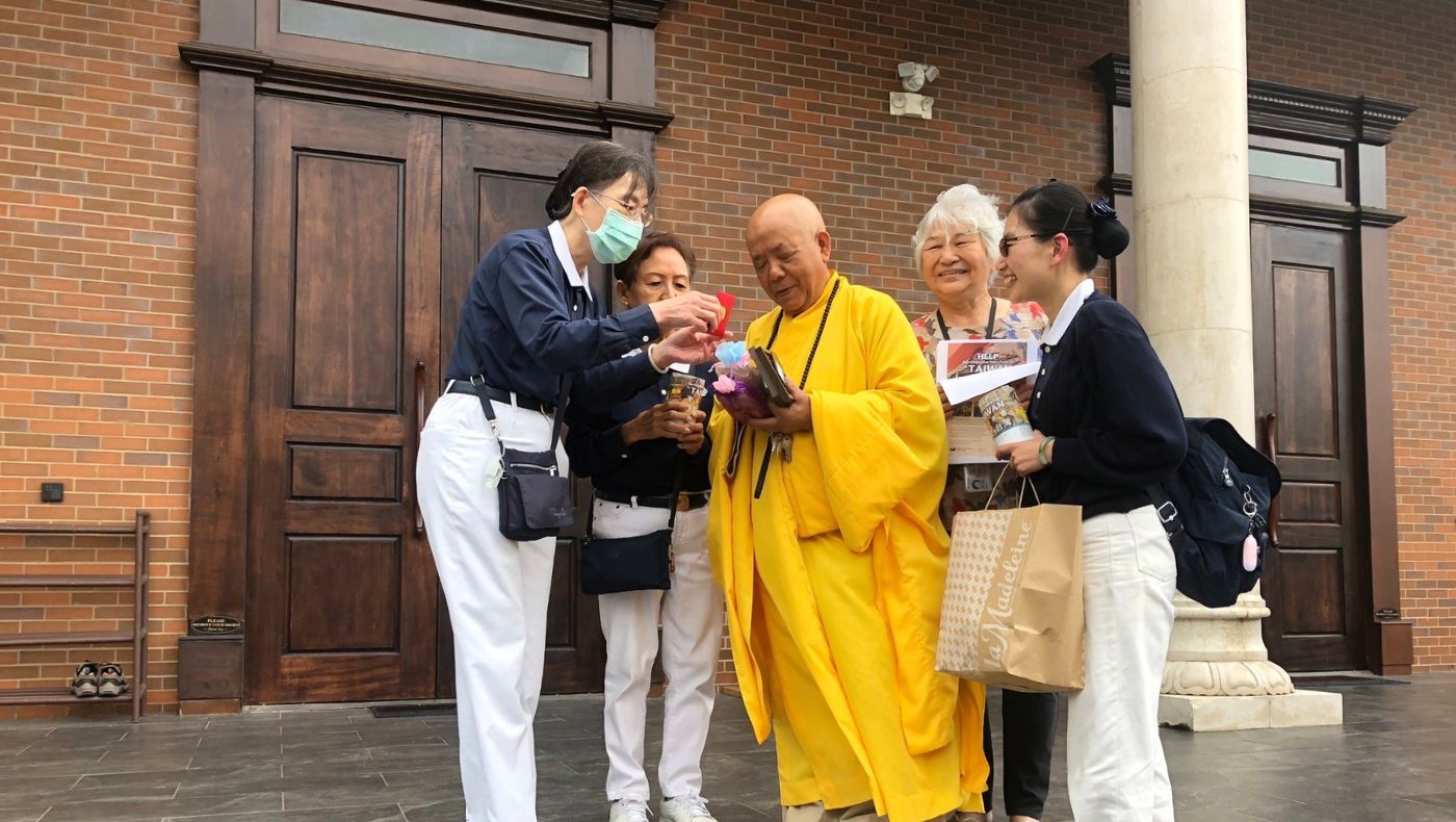 Representative volunteer Liang Mingchan presented blessing and wisdom red envelopes and small souvenirs to Master Yuanda to thank him and fellow Buddhists for their support.