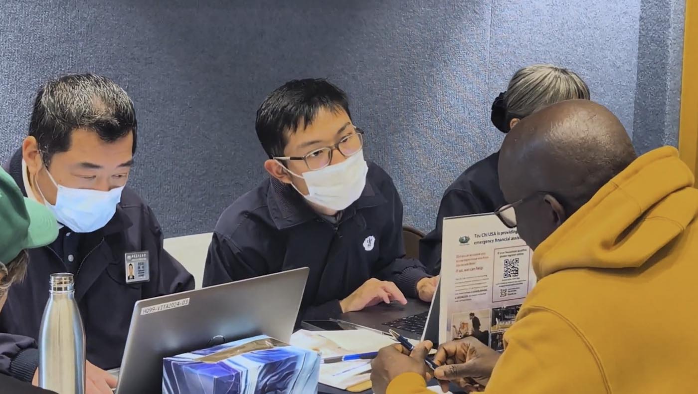 慈濟志工在災後復原中心室內的慈濟攤位上為災民服務。圖片來源／視頻截圖（攝影者門海梅 Jaime Puerta）