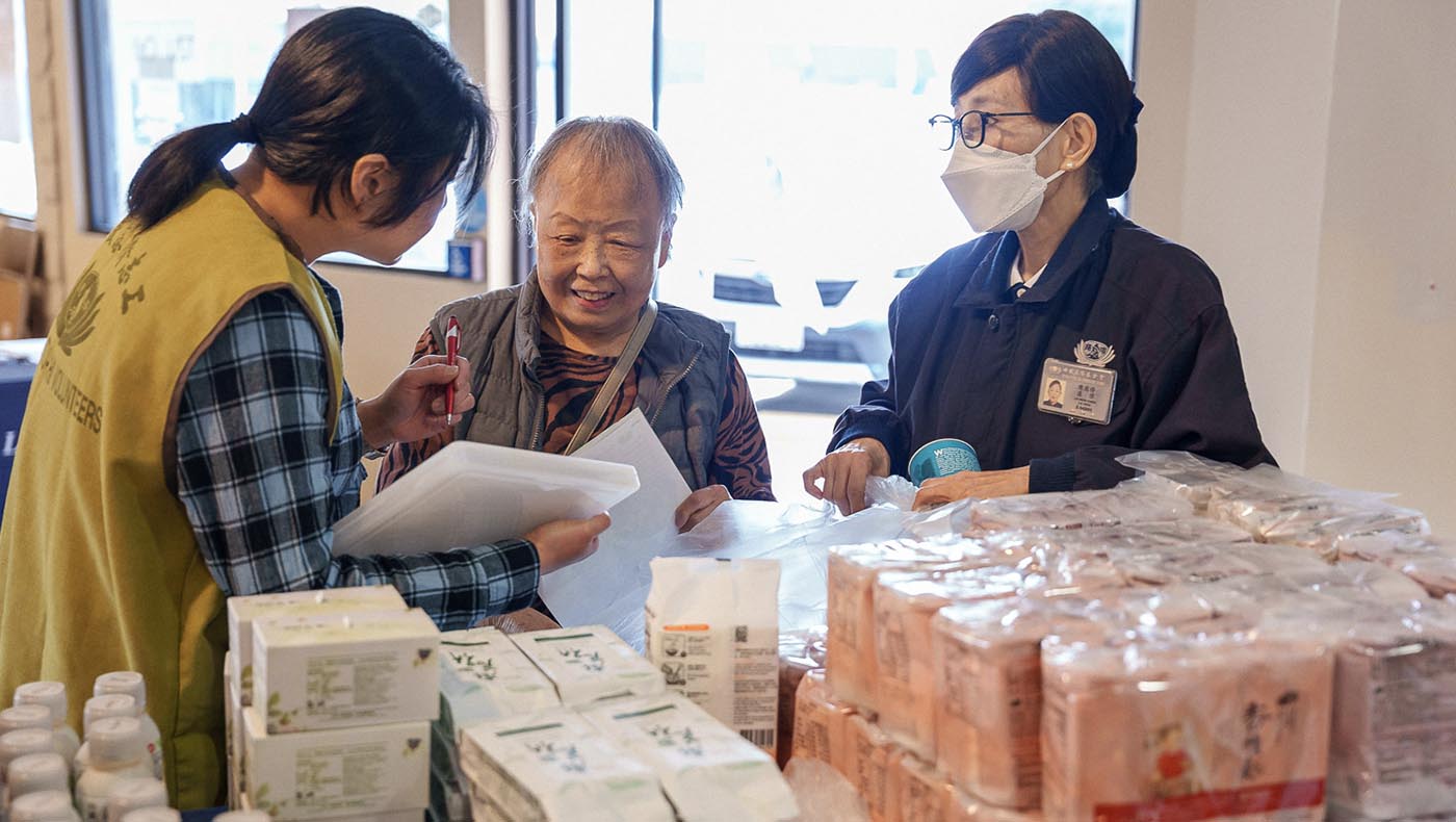 志工為安娜．衛（中）介紹可供選擇的應急食品。攝影／門海梅
